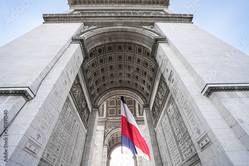 Foto Wide angle photo with the National Flag of France waving under the Arch of Triumph landmark building during Armistice Day