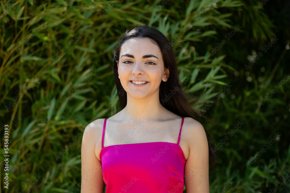 Portrait of a happy lovely and beautiful Spanish young woman in a park.