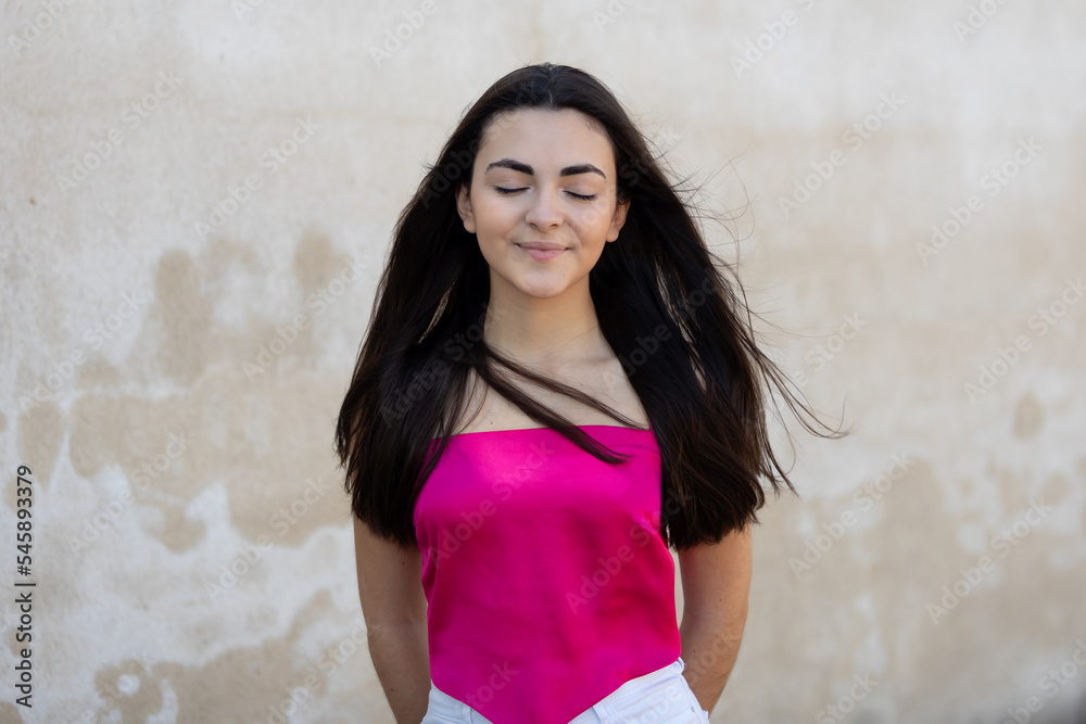 Fototapeta premium Portrait of a happy lovely and beautiful Spanish young woman in a park.