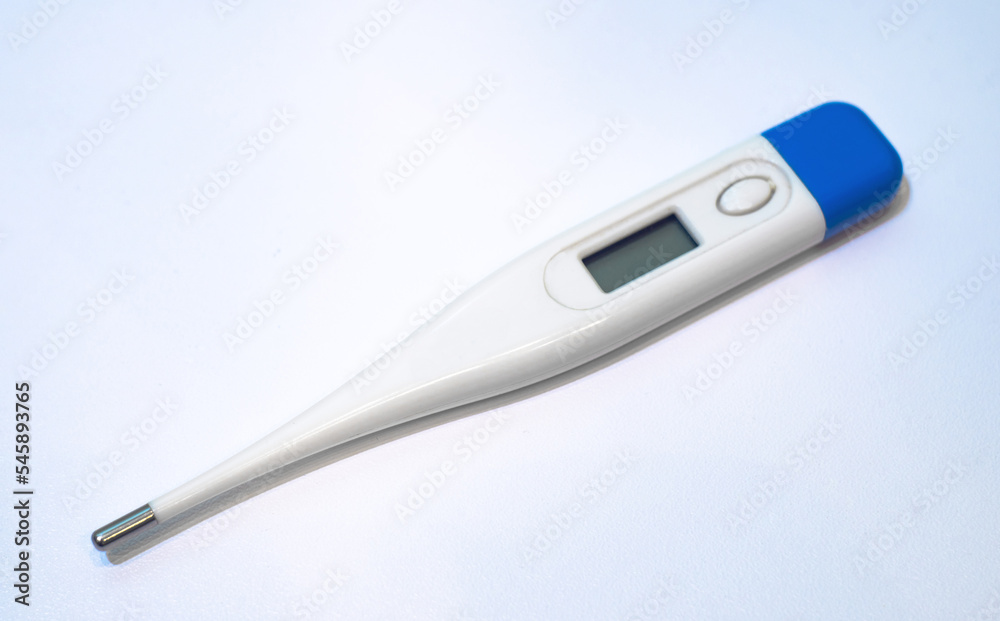 White electronic thermometer for temperature measurement. Thermometer on white isolate. A medical thermometer on a white table. White electronic thermometer for temperature measurement. Thermometer on white isolate. A medical thermometer on a white table.