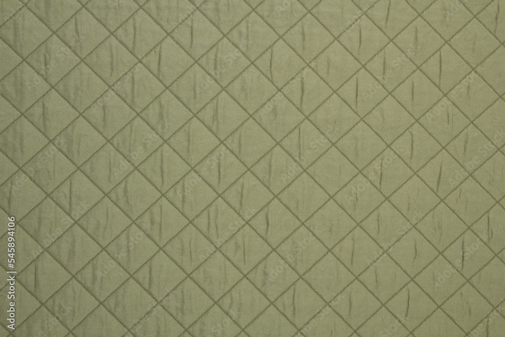 Fototapeta premium Quilted fabric green. The texture of the blanket.