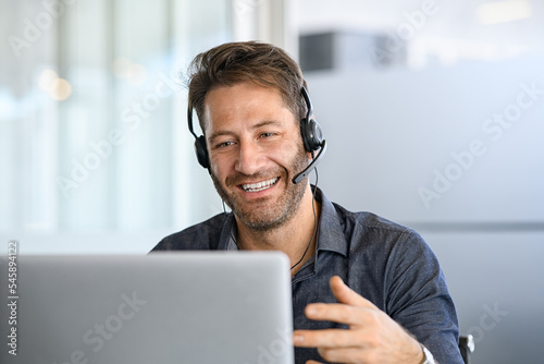 Cheerful mid adult man having video call on laptop
