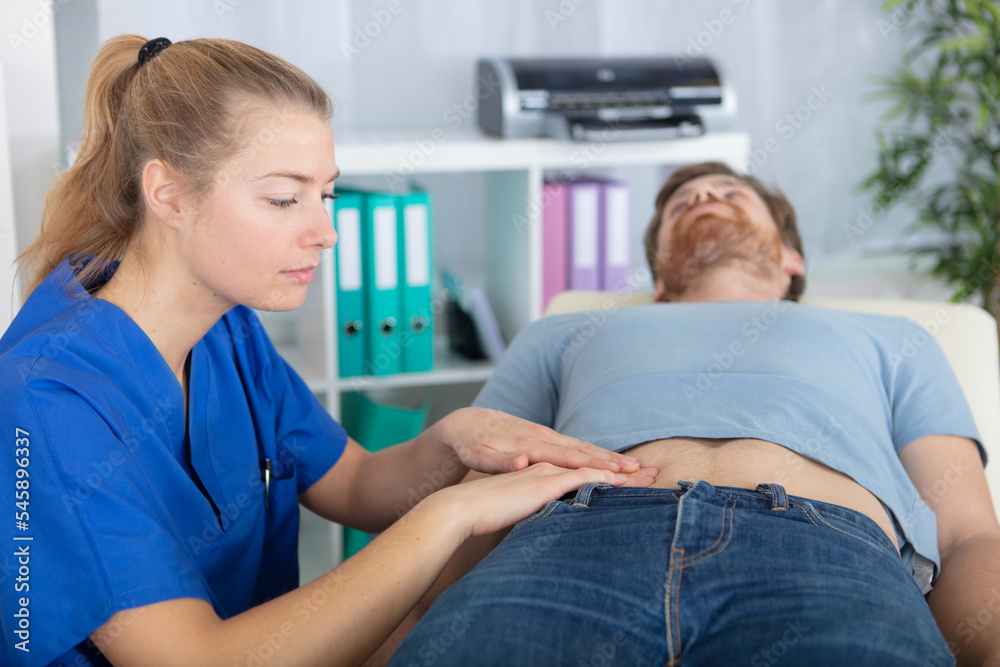 young attractive female doctor with male patient young attractive female doctor with male patient