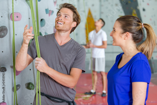 climber checking ropes before climbing indoor wall