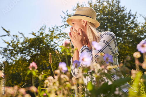 Woman with runny nose or hay fever when sneezing photo
