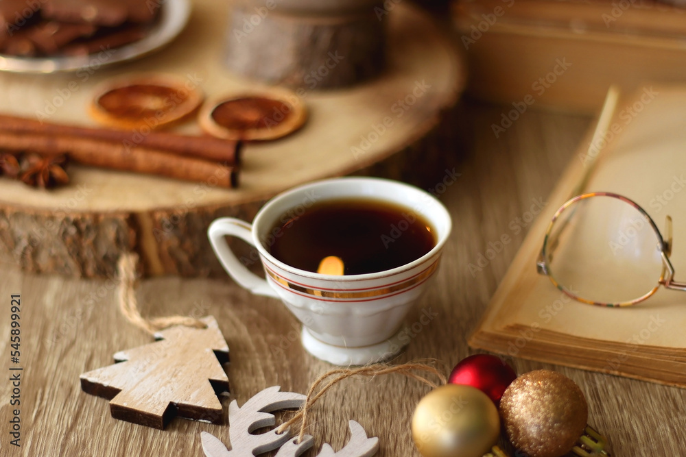 Cup of tea or coffee, various sweets and spices, Christmas decorations, comfy blanket, books and glasses. Selective focus. Cup of tea or coffee, various sweets and spices, Christmas decorations, comfy blanket, books and glasses. Selective focus.