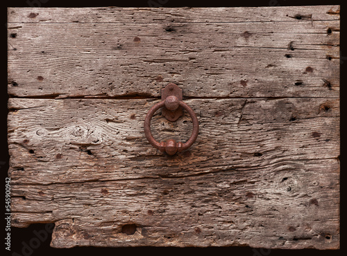 Detail einer historisch alten Tür aus verwitterten Holz mit rostigen Türklopfer photo