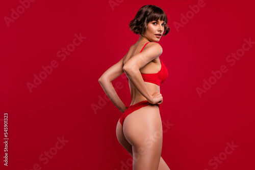 Profile side view portrait of attractive gorgeous nude girl posing perfect thin fit figure isolated over bright red color background
