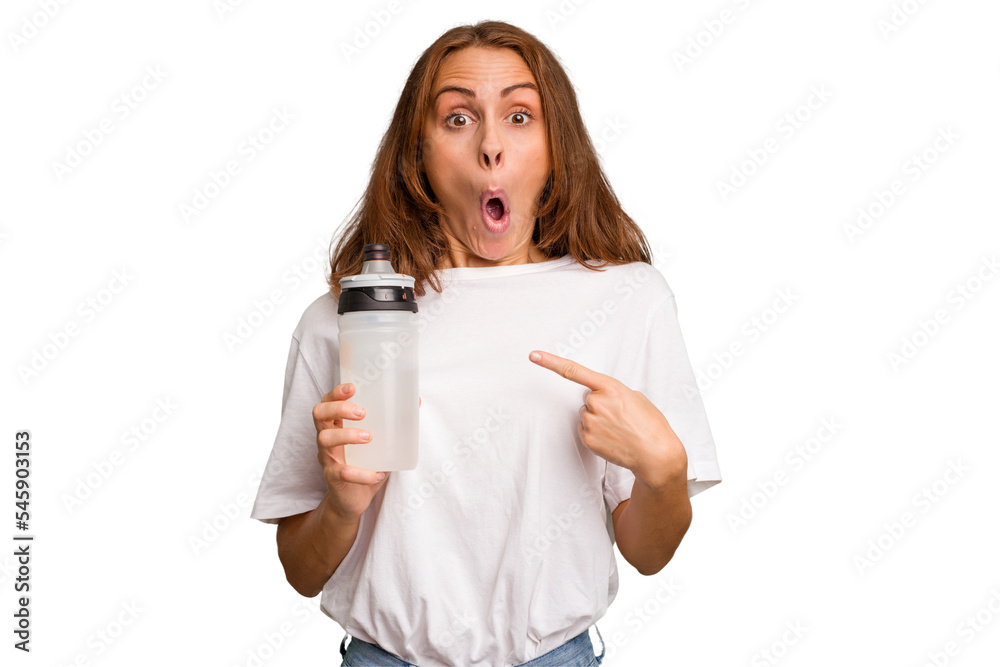 Young caucasian sport woman holding a bottle of water isolated pointing to the side Young caucasian sport woman holding a bottle of water isolated pointing to the side