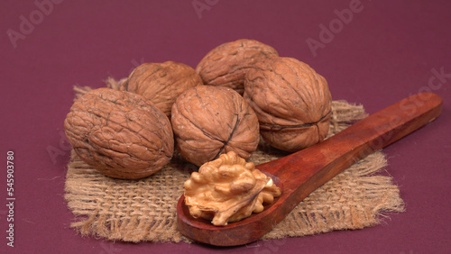 Closeup photo of a walnut seed in wooden bowl. Food that is good for brain and lower risk of heart disease.