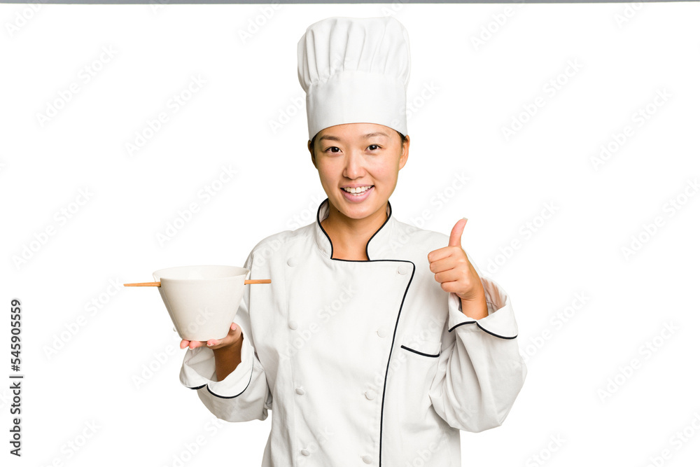 Young chef asian woman holding a bowl of ramen isolated smiling and raising thumb up Young chef asian woman holding a bowl of ramen isolated smiling and raising thumb up
