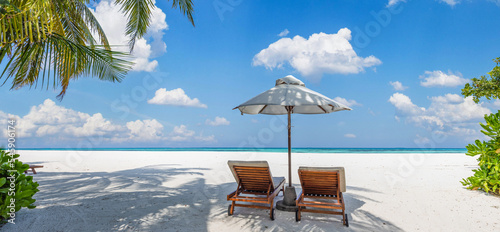 Fototapeta Naklejka Na Ścianę i Meble -  Beautiful tropical beach banner. Couple chairs scene, white sand coco palms travel panorama. Sunny summer sea, idyllic island nature shore. Amazing landscape. Luxury beach resort vacation or holiday
