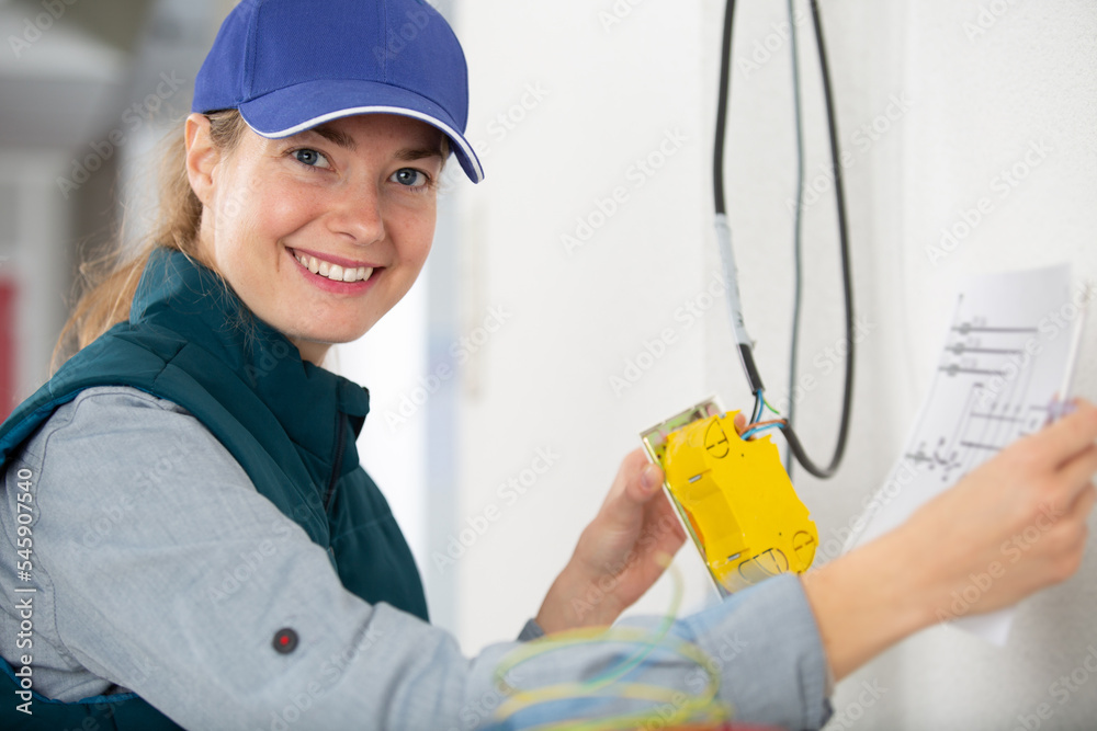 female electrician is smiling at the camera female electrician is smiling at the camera