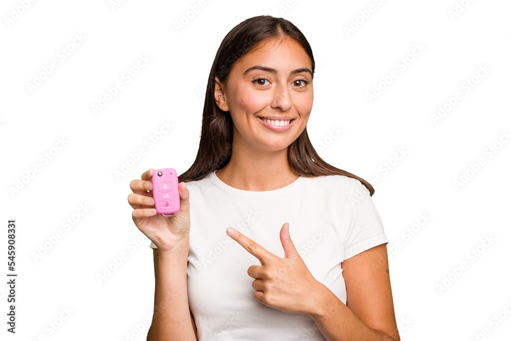 Young caucasian woman holding a car keys isolated smiling and pointing aside, showing something at blank space. Young caucasian woman holding a car keys isolated smiling and pointing aside, showing something at blank space.