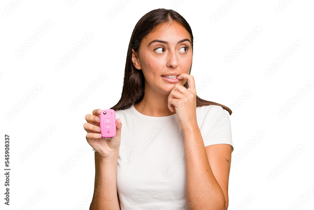 Young caucasian woman holding a car keys isolated relaxed thinking about something looking at a copy space. Young caucasian woman holding a car keys isolated relaxed thinking about something looking at a copy space.