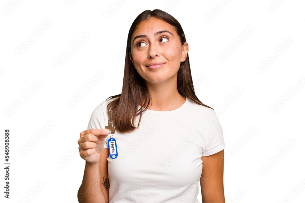 Young caucasian woman holding a home keys isolated dreaming of achieving goals and purposes Young caucasian woman holding a home keys isolated dreaming of achieving goals and purposes