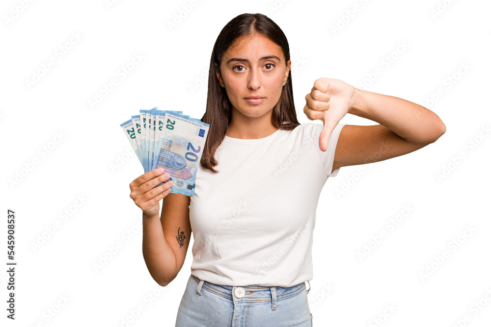 Young caucasian woman holding a banknotes isolated showing a dislike gesture, thumbs down. Disagreement concept. Young caucasian woman holding a banknotes isolated showing a dislike gesture, thumbs down. Disagreement concept.