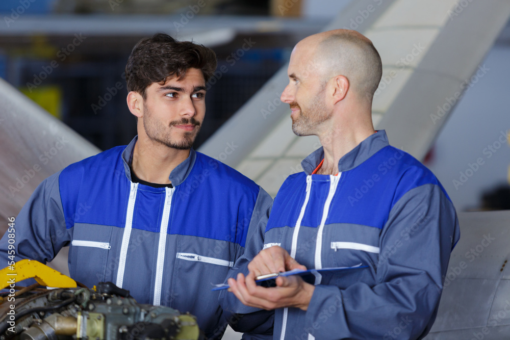 airplane service crew repairing plane in hangar