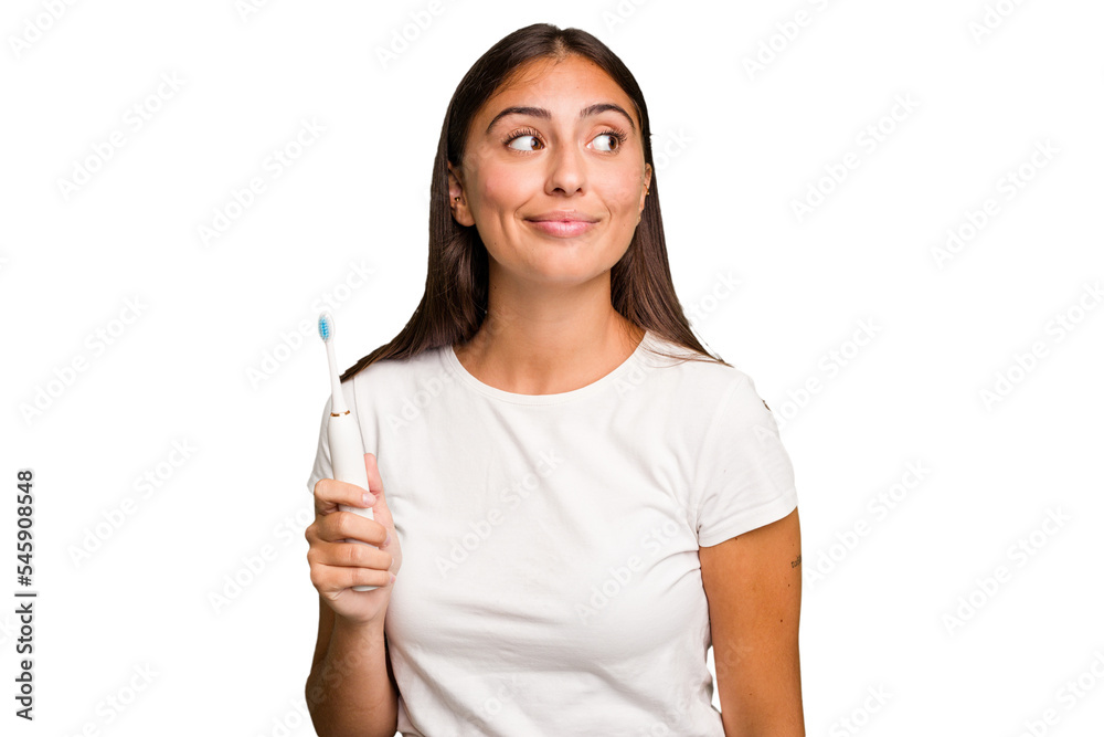 Young caucasian woman holding an electric toothbrush isolated dreaming of achieving goals and purposes Young caucasian woman holding an electric toothbrush isolated dreaming of achieving goals and purposes