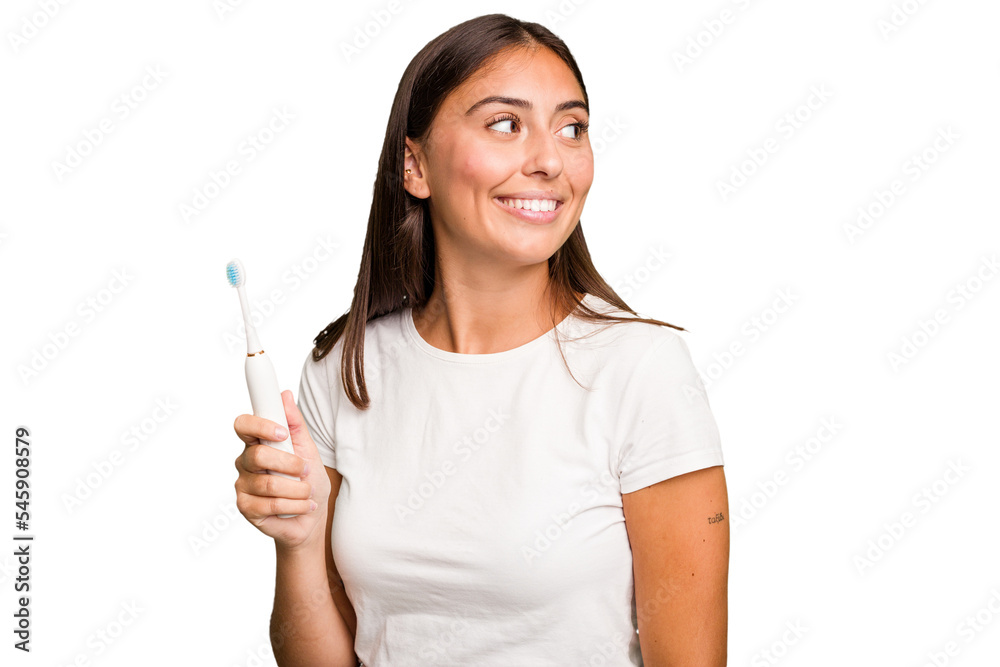 Young caucasian woman holding an electric toothbrush isolated looks aside smiling, cheerful and pleasant. Young caucasian woman holding an electric toothbrush isolated looks aside smiling, cheerful and pleasant.
