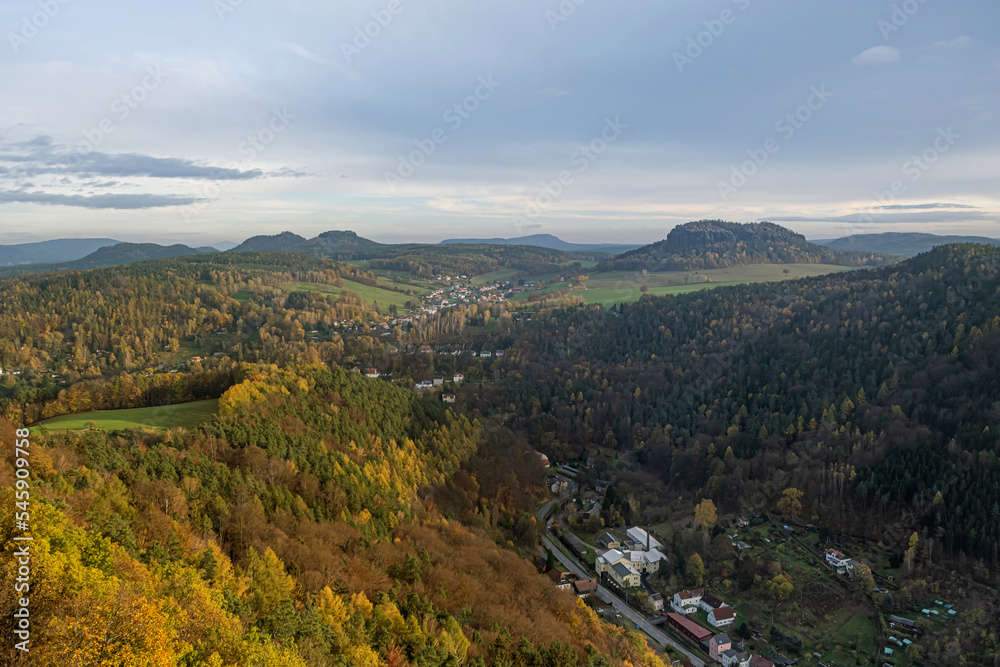 Autumn Saxon Switzerland view from the hill. City under the sunset sky in the valley between the hills. High quality photo