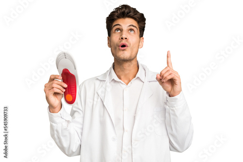 Young caucasian chiropodist man isolated pointing upside with opened mouth.
