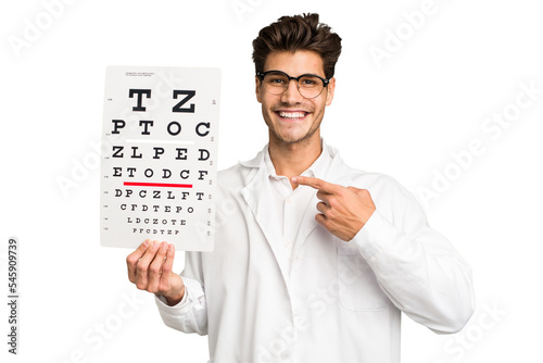 Young caucasian oculist man isolated smiling and pointing aside, showing something at blank space. photo