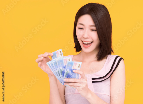 happy young counting money and isolated on yellow background