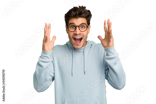 Young caucasian handsome man isolated celebrating a victory or success, he is surprised and shocked.