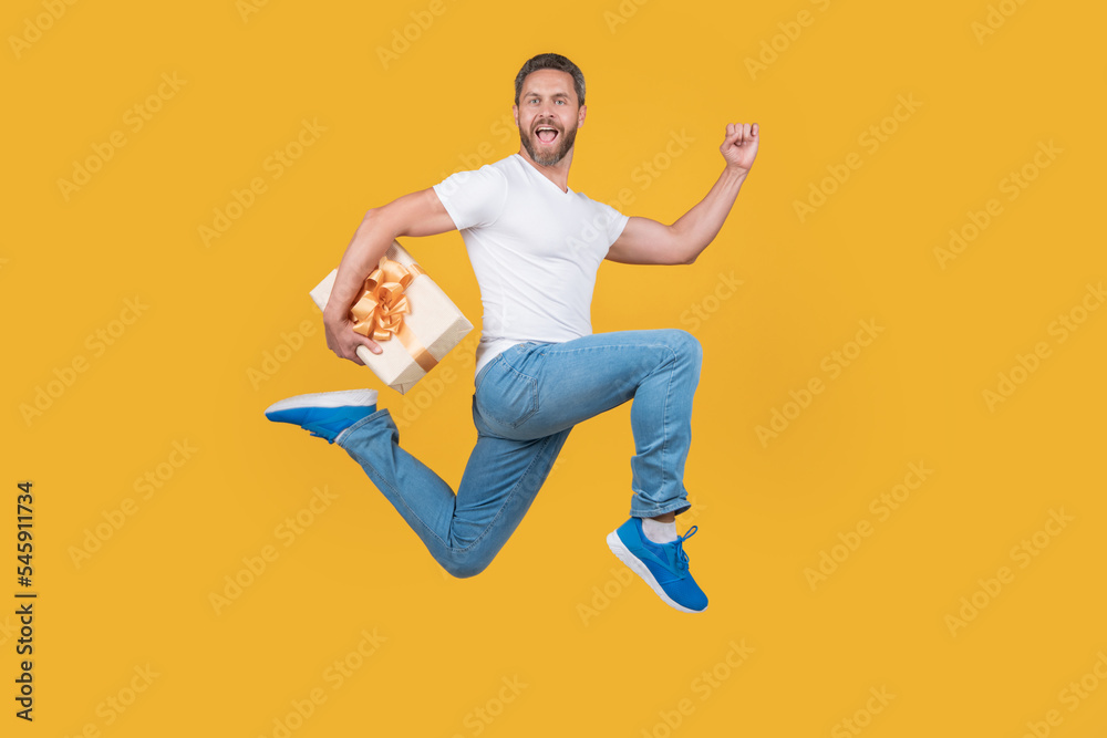 Active man running fast with gift box. Gift courier in midair. Present and gift delivery Active man running fast with gift box. Gift courier in midair. Present and gift delivery