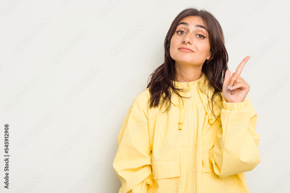 Young Indian woman isolated on white background showing number one with finger. Young Indian woman isolated on white background showing number one with finger.