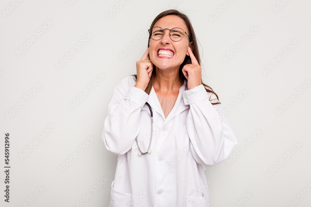 Young doctor woman isolated on white background covering ears with hands. Young doctor woman isolated on white background covering ears with hands.