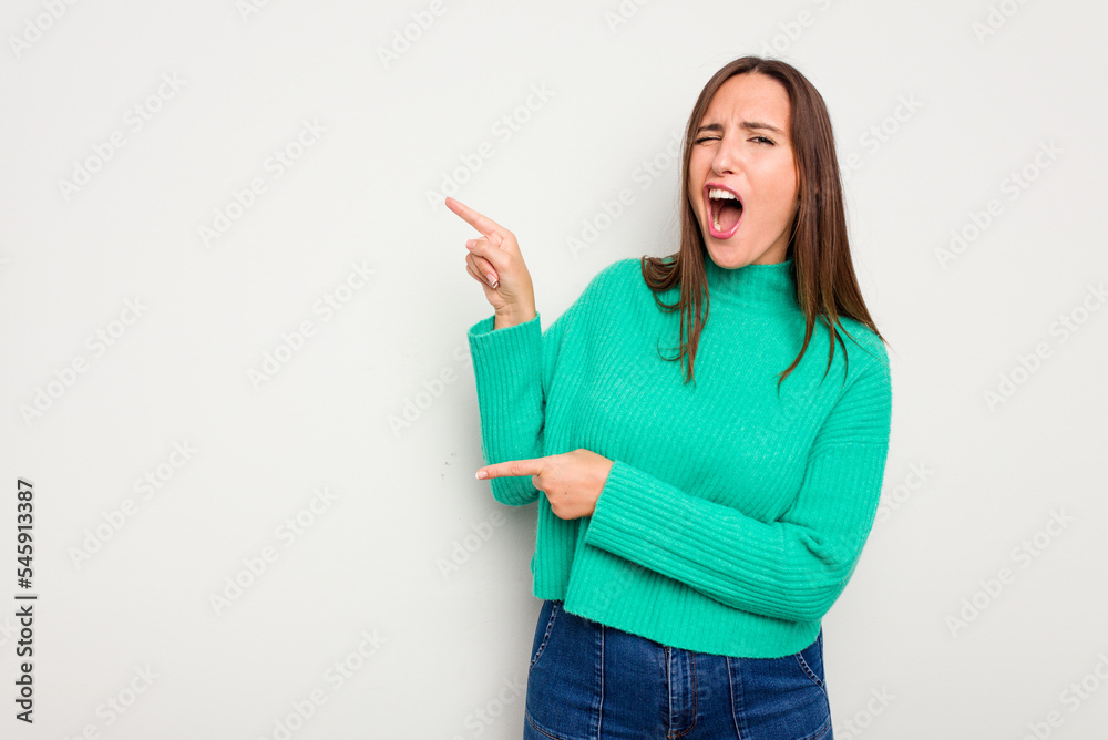Young caucasian cute woman isolated on white background pointing with forefingers to a copy space, expressing excitement and desire.
