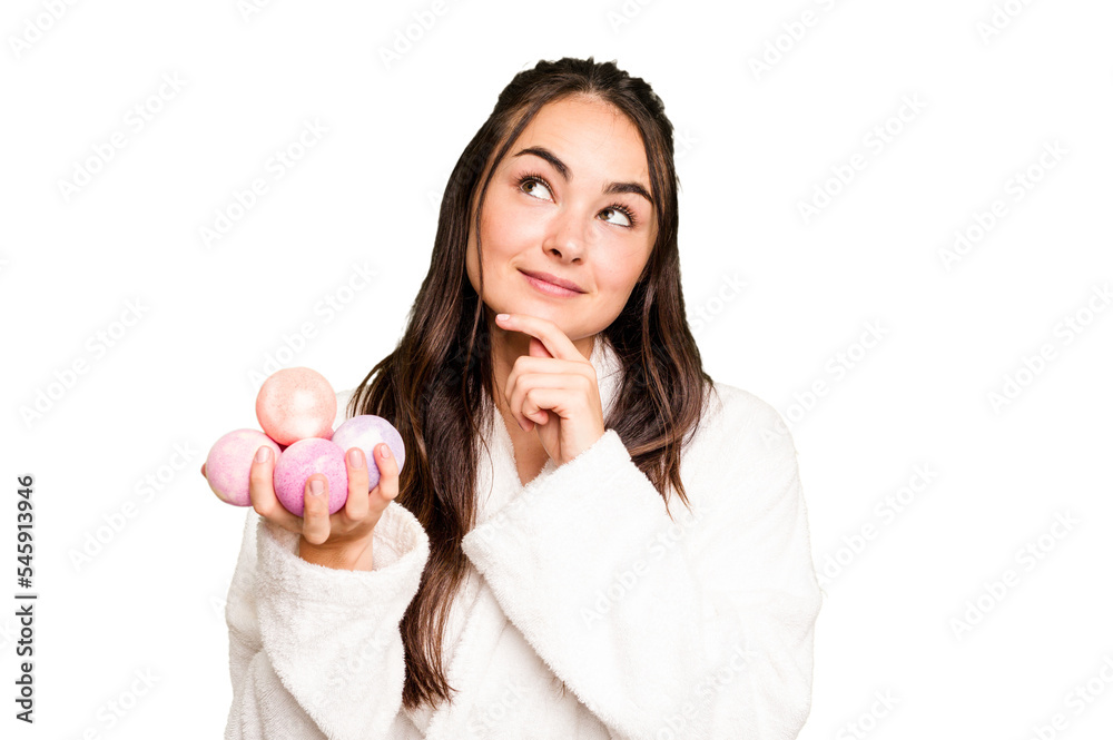 Young caucasian woman holding aromatic balls for bathtub isolated on green chroma background looking sideways with doubtful and skeptical expression. Young caucasian woman holding aromatic balls for bathtub isolated on green chroma background looking sideways with doubtful and skeptical expression.