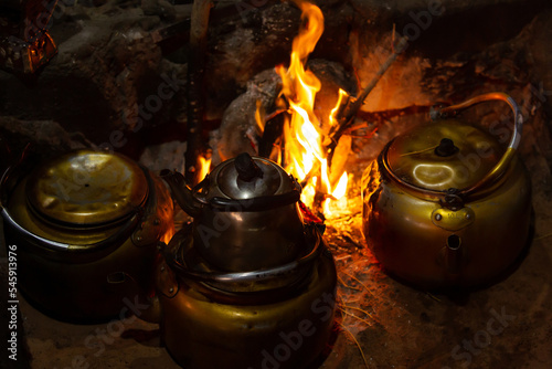 Canvas-taulu Few teapots with Bedouin tea, kettle on campfire at night, Jordan, Wadi Rum