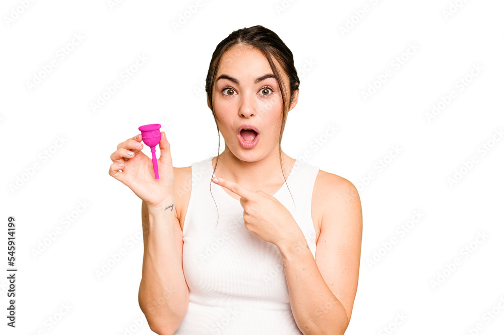 Young caucasian woman holding menstrual cup isolated on green chroma background pointing to the side Young caucasian woman holding menstrual cup isolated on green chroma background pointing to the side