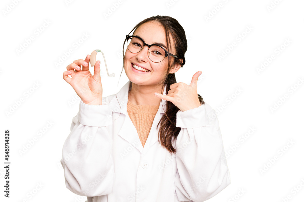 Young otorhinolaryngologist holding hearing aid isolated on green chroma background showing a mobile phone call gesture with fingers. Young otorhinolaryngologist holding hearing aid isolated on green chroma background showing a mobile phone call gesture with fingers.