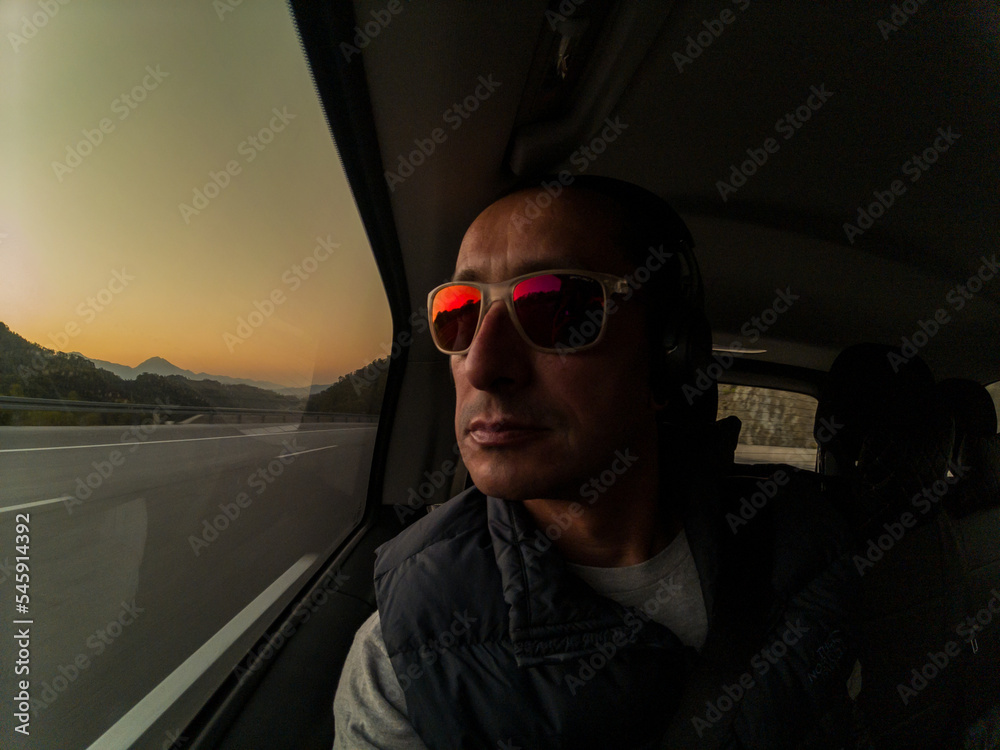 Man inside the car close up at sunrise, travel concept