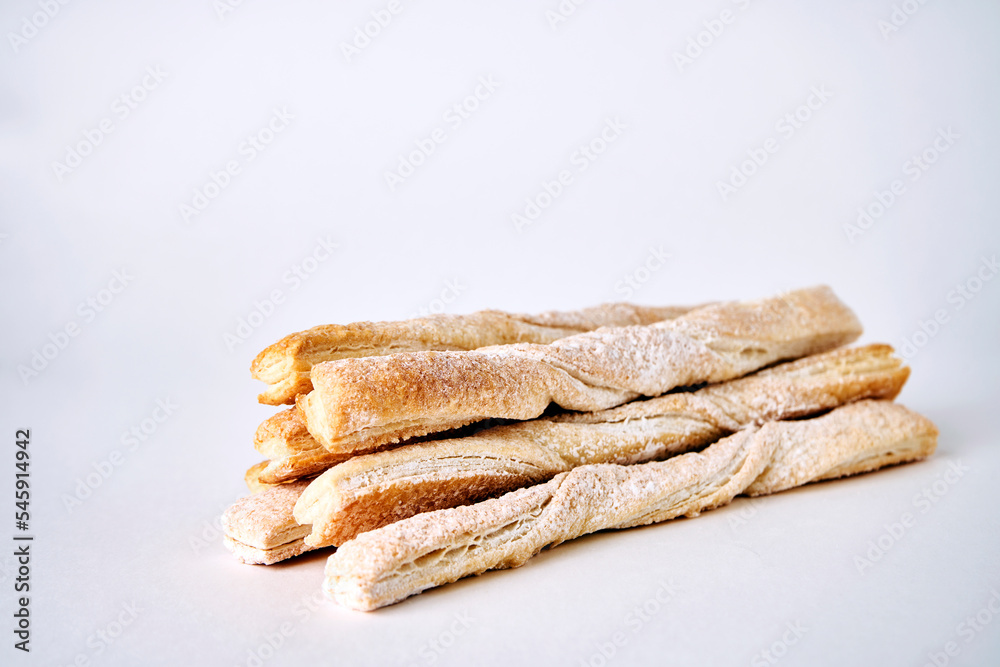 Puff pastry sticks with cinnamon on white background