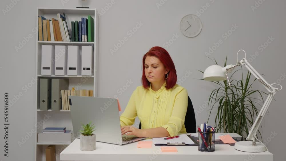 Woman working from home office using laptop sitting on chair. Young female typing on laptop. Work from home concept Woman working from home office using laptop sitting on chair. Young female typing on laptop. Work from home concept