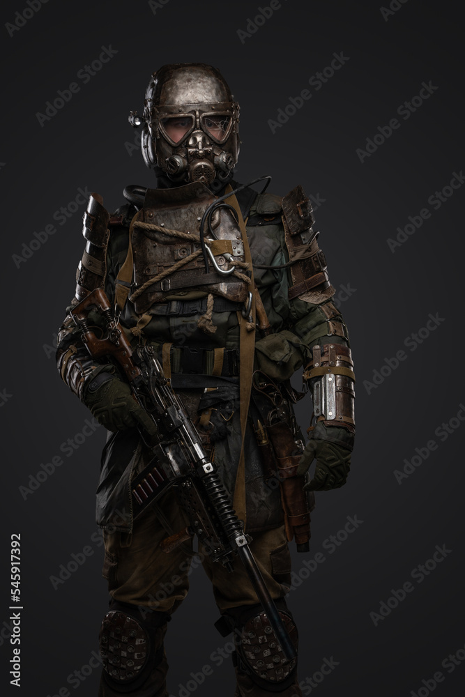 Shot of post apocalyptic soldier dressed in armour and gas mask holding shotgun.