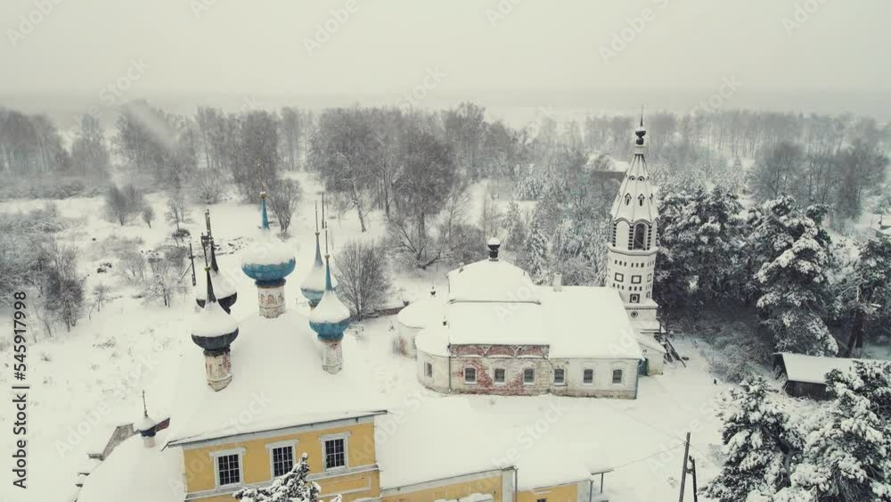 Aerial view of a snowy village with a church in winter. Central Russia. Fabulous winter natural landscape, background, screensaver, footage, video. UHD 4K. Aerial view of a snowy village with a church in winter. Central Russia. Fabulous winter natural landscape, background, screensaver, footage, video. UHD 4K.