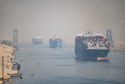 Many cargo ships navigate by Suez Canal, Egypt. Concept of distribution, shipping and delivery