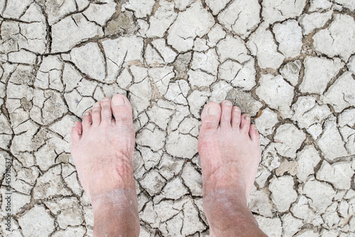 barefoot standing on the cracked ground
