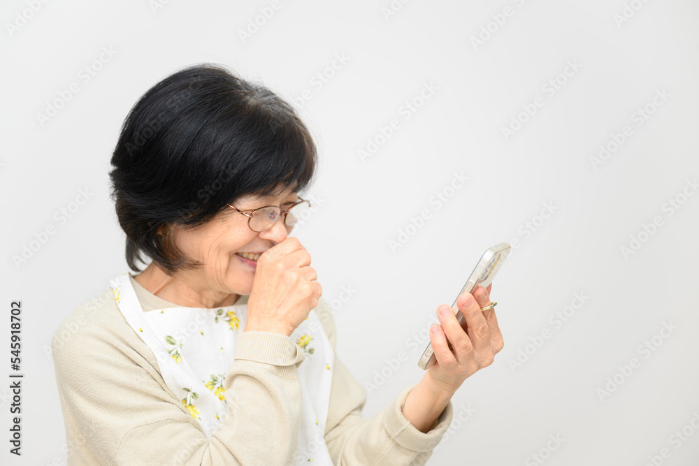 スマホをみて大笑いする高齢者