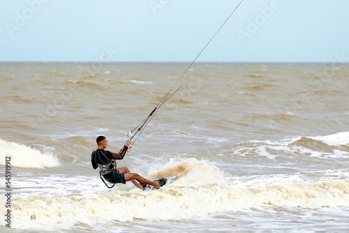 A young kiteboarder rides the waves into the sea