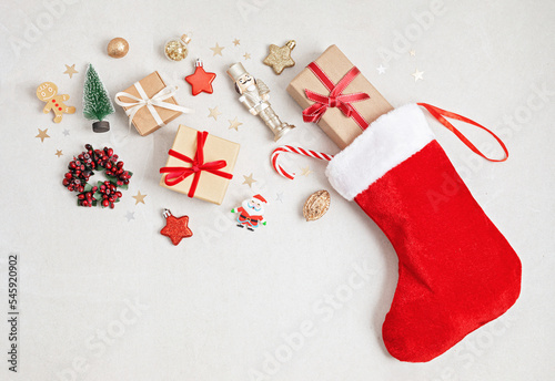 Red Christmas stocking with gifts and decoration. Traditional Xmas celebration concept photo