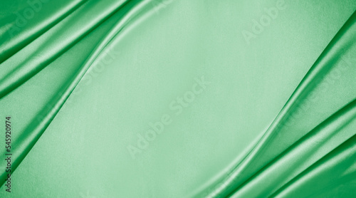 Light blue green silk satin. Mint color shiny silky smooth fabric. Soft wavy folds. Elegant background with space for design. Banner. Flat lay, top view table. Template. Romance, Valentine, Wedding.