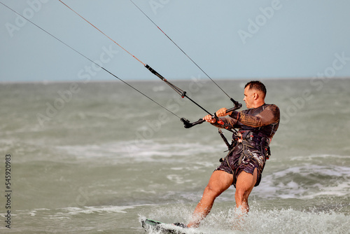 Adult man surfing on a kite in the sea