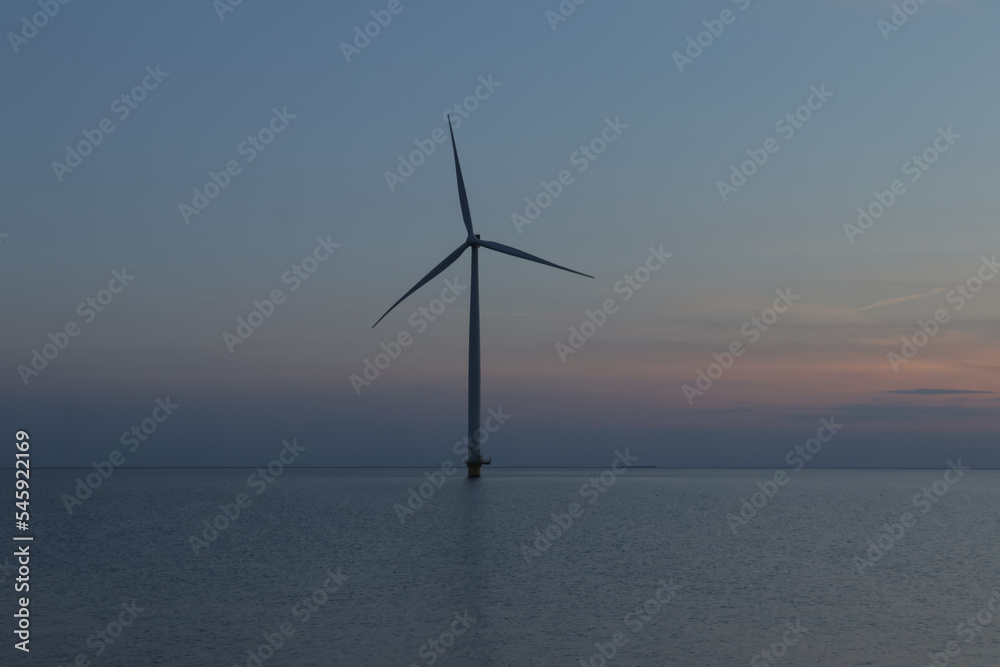 Aerial photo of wind turbines in the sea during sunset